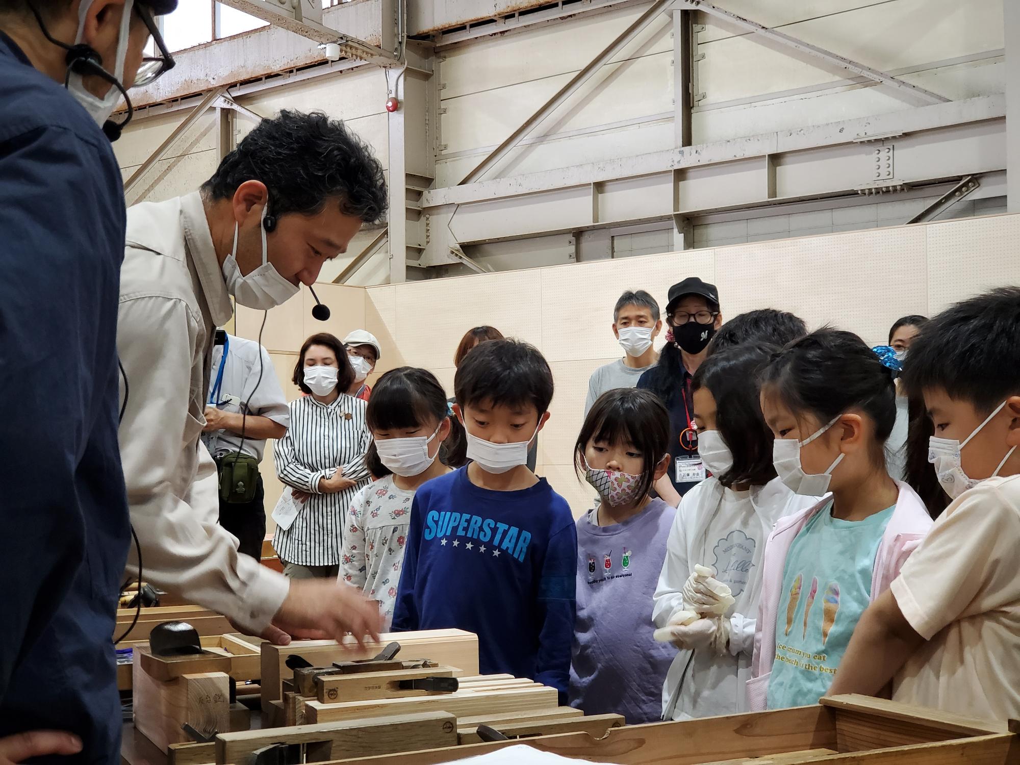 大工道具の説明を聞く参加者
