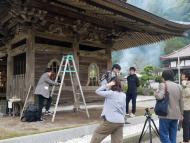 山門を飾る彫刻の撮影準備をしている何人かの人が写っている写真