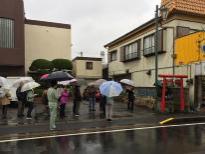 商店街にある赤い鳥居が佇む三峯神社を訪れる男女が映っている写真
