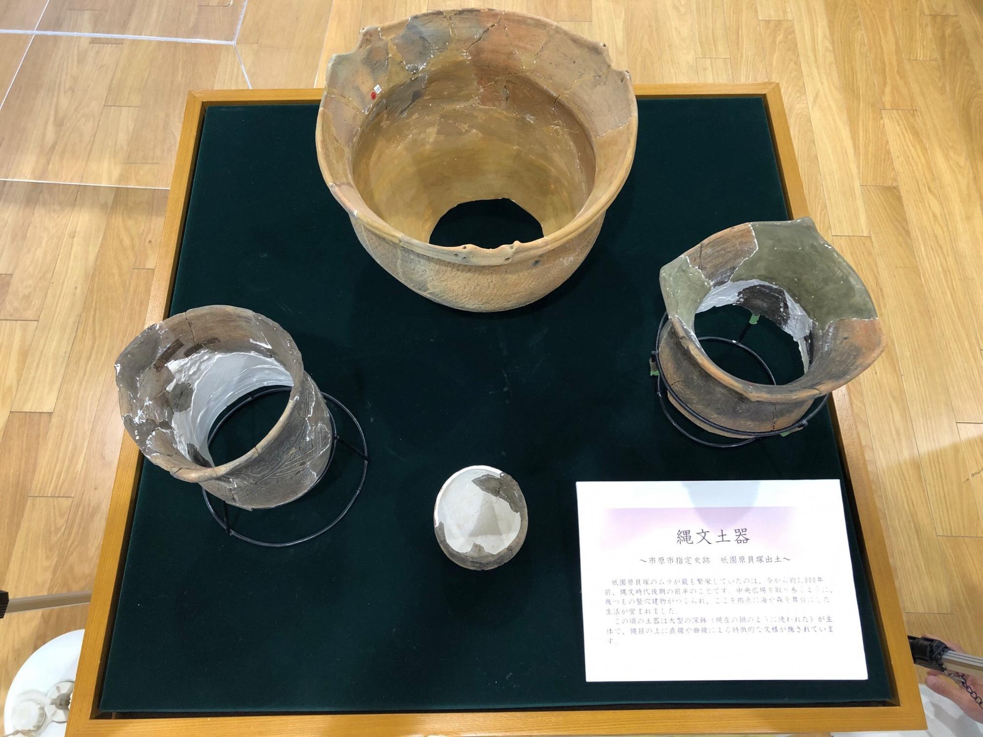 ショーケースの中に3点の縄文土器が展示されている写真