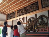 光厳寺本堂の欄間彫刻の調査を行う男女の写真