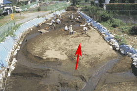 墳丘下の皿状遺構で作業をしている作業員を写した写真