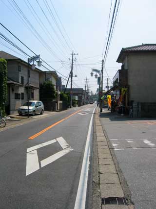 片側1車線の通りで、車道の両側に住宅が立ち並んでいる通りの写真