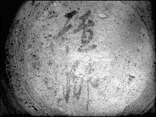 第8号住居址出土の土師器坏底部外側に残る墨書の写真、詳細は右記