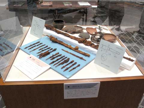 ガラスで囲まれた展示ケースの中に出土品が展示されている写真