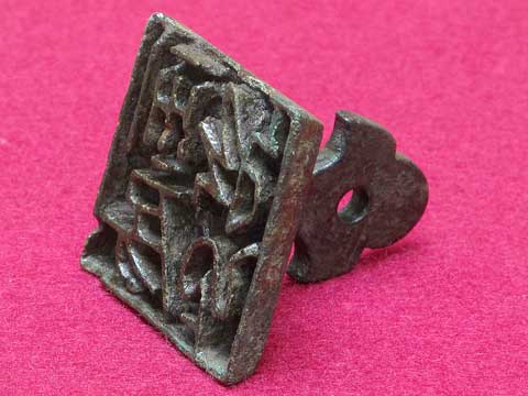 ピンク色のマットの上に置かれた押す面が四角い銅製の印の写真