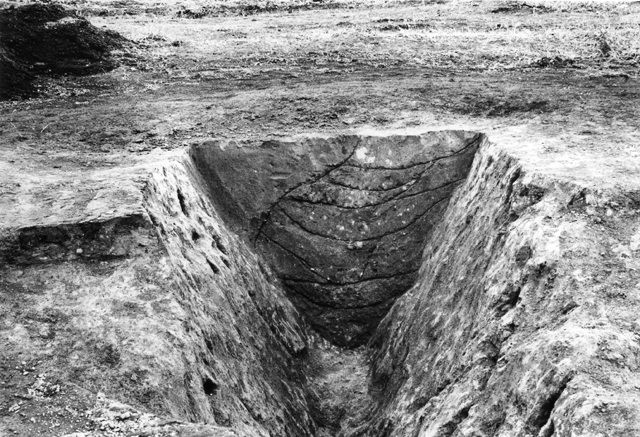 地面がV字に大きく彫られている菊間遺跡の環濠のモノクロの写真