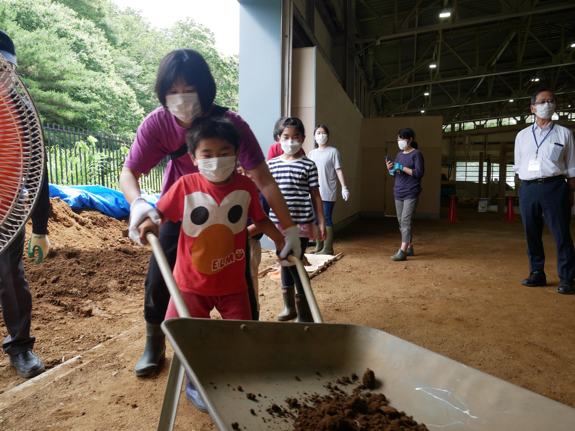 土を竪穴建物の屋根へ運ぶ