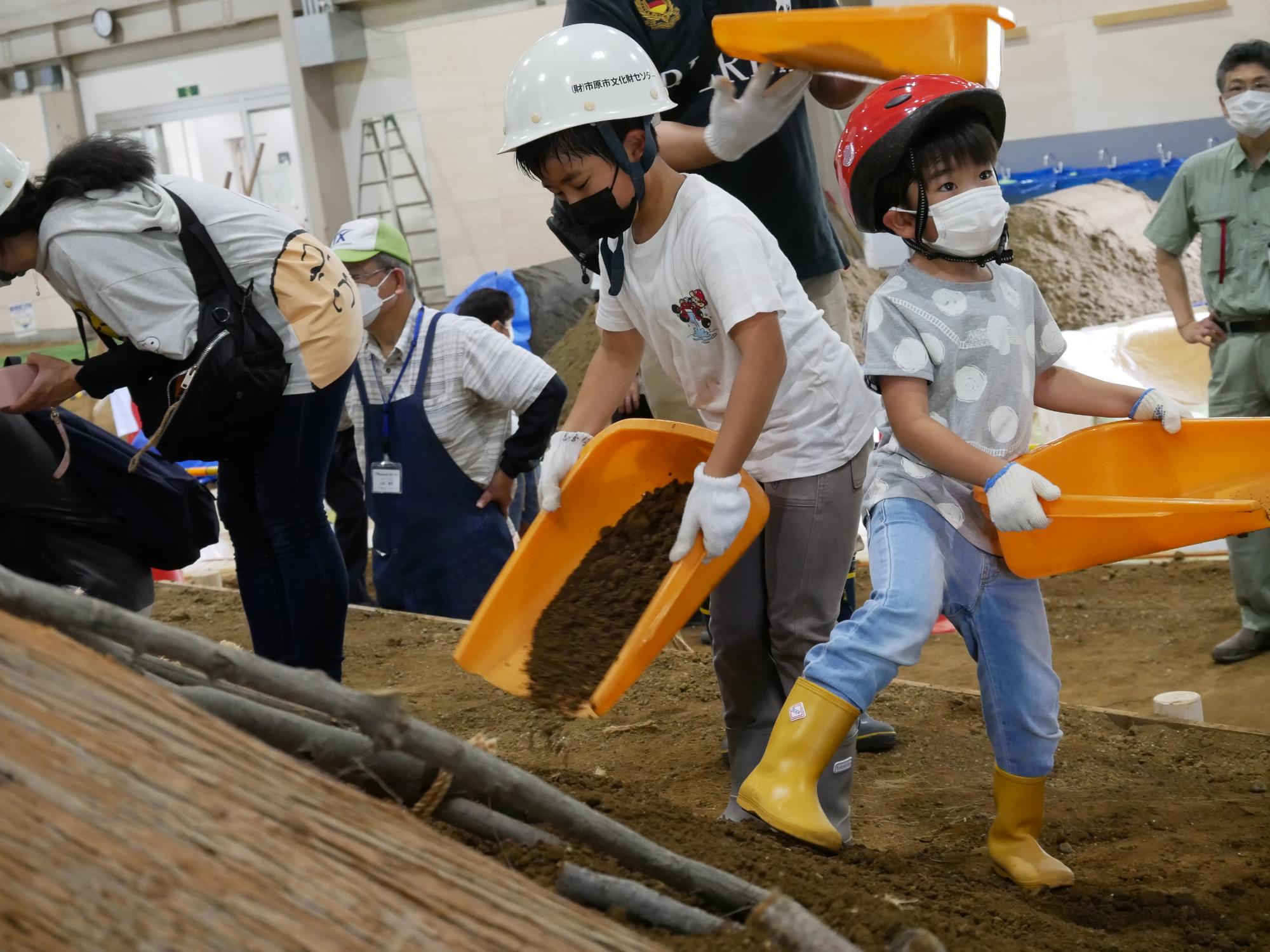 土を竪穴建物の屋根に敷く