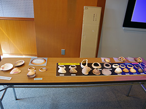 現生貝を使った貝輪複製品が机の上に展示されている写真
