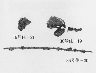 上に二つ、下に一つ出土品が並べられている写真、左上には大きく欠けた紡輪、16号住-21と書かれている、右上には4分の1ほど欠けた紡輪と短い紡軸、36号住-19と書かれている、下には途中で折れている紡軸、36号住-20と書かれている