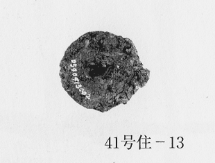 欠けのないと思われる紡輪、直接円にそって白く10桁の数字が書かれており、写真右下に41号住-13と書かれている写真