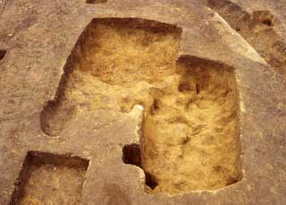 四角が2つずれてくっついたような形で土が彫られた跡の写真