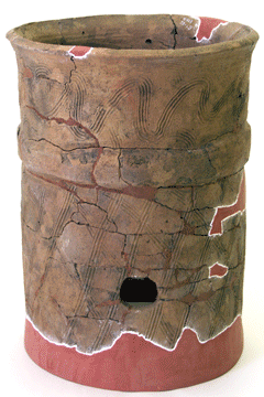 茶色で下部に丸い穴があいていおり、波状の模様がある出土した破片と粘土でよみがえった円筒は埴輪の写真