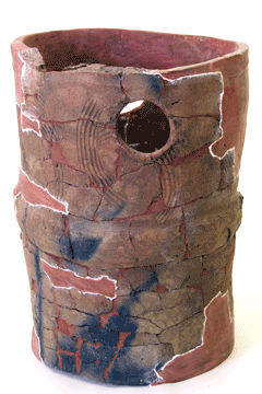 茶色で上部にに丸い穴があいていおり、下部には黒斑がある出土した破片と粘土でよみがえった円筒は埴輪の写真