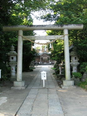 鳥居から続く参道の奥に木々に囲まれた島穴神社の本殿がある写真