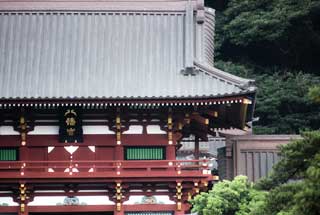 屋根に曲線を与えた流造（ながれづくり）で、柱や柵が朱色に塗られた鶴岡八幡宮の写真