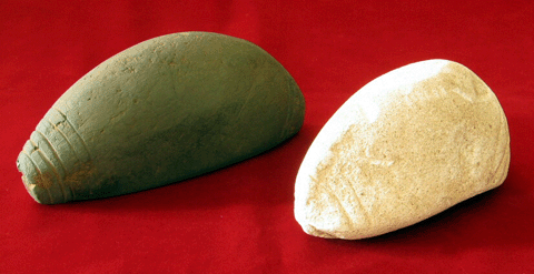 太いブーメランのような形で両端付近には線で模様が付けられた灰色と白色の2つの石の写真