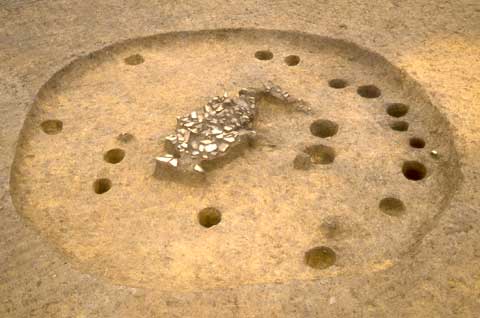 大きな円のへこみの中に複数の小さい穴が空いており、中央に魚のような形をした出っぱりがある文作遺跡の竪穴住居跡