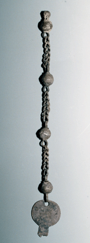錆びたような色で、鎖に4つの玉が等間隔につけられ、一番下には平たい丸のような装飾がついている銀製耳飾りの写真