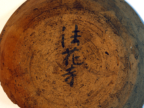 白い背景で、茶色く丸い土師器杯の底部に墨と筆で法花寺と書かれている写真