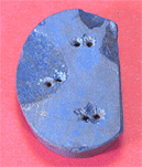 ピンク色の背景に、群青色で楕円を三分の一ほど切りとったような形状の、小さな穴が六つあいている帯の装飾の写真