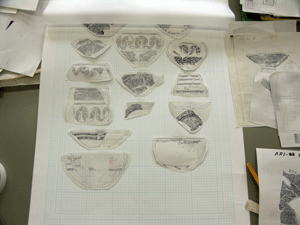 5ミリメートル方眼の紙にトレースした土器の絵を形に切り取ったものを並べている写真
