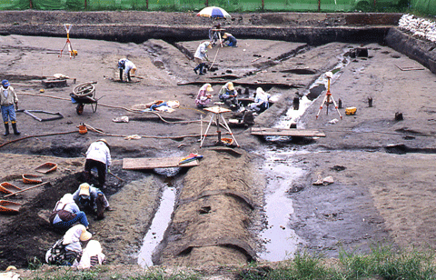 八幡御墓堂遺跡の発掘調査をしている10人ほどの人々が写っている写真