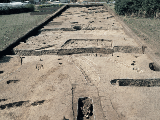 南岩崎遺跡の環濠集落と下部に出土した土器が写っている写真