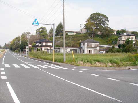 道路、横断歩道、家が写る南東側よりの小野山城跡近景の写真