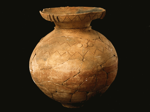 ジグザグ線が描かれている茶色で丸みを帯びた壺形の土器の写真