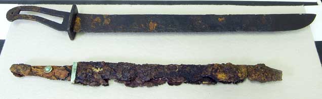 写真の下側の鉄刀は、2号基壇の鎮壇具として埋められていて、上の刀は柄の形から「蕨手刀」と呼ばれる特殊な刀で、市内の別の遺跡から見つかったという写真