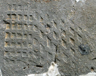 石に2種類の格子がL字に伸びているように押印されている写真