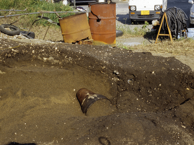 土の中から茶色い土器が発見された写真。